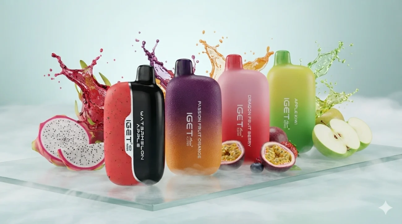 
High-end commercial product banner featuring four colourful IGET Moon K5000 vape devices standing in a staggered line on a frosted glass surface. Surrounding the devices are dynamic micro-splashes of fruit juice, sliced dragon fruit, crisp green apples, and halved passion fruit.
